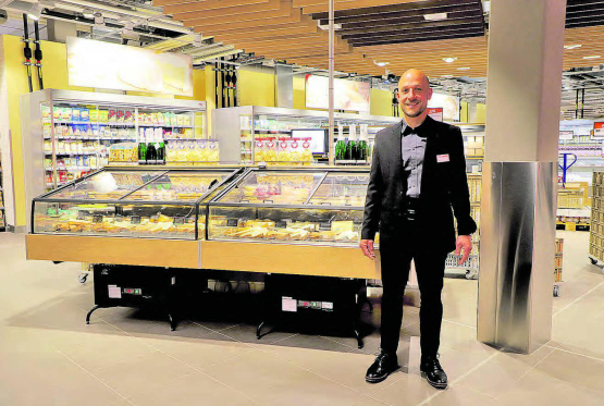 Der Reinacher nahm sich Zeit für einen kurzen Rundgang: Migros Marktleiter Marcel Weltert vor der neuen Käse-Theke. (Bild: rc.)