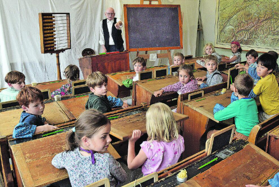 Ein Schulzimmer, wie es die Urgrosseltern erlebten: «Schulmeister» Hannes Gasser fragt die zweite Klasse nach den Unterschieden zur heutigen Ausstattung. (Bilder aw.)