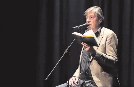 Auf grosser Bühne vor kleinen Tischchen und einem interessierten Publikum: Pedro Lenz las im Saalbau Reinach aus seinem Buch «Primitivo». (Bild: zVg.)