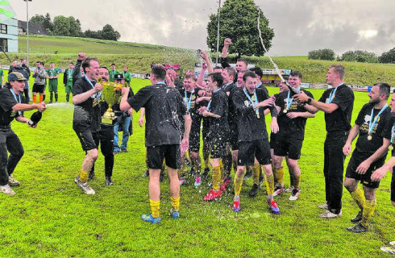 Pure Freude über den Wiederaufstieg: Die Spieler von Gunzwil II feiern mit einer Champagner-Dusche. (Bild: mm.)