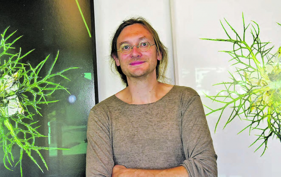 Abstraktes Wurzelwerk in schwarzem und weissem Hintergrund? Künstler Olivier Lorenz Schmid vor den beiden Fotos im Foyer des Schulzentrums Schöftland. (Bild: aw.)