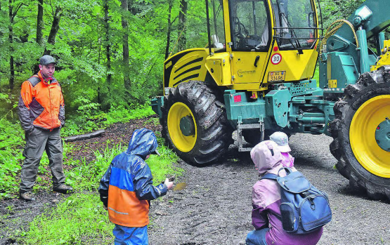 Kinder spielen im Schlamm: Für den Forstspezialschlepper interessierten sie sich vorerst nicht, links Maschinist Simon Engel. (Bilder: aw.)