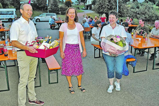 Genug Abstand: Patric Jacob und Gemeinderätin Stephanie Weber-Gloor überreichen Festrednerin und Krimiautorin Ina Haller (Mitte) einen Blumenstrauss und einen Korb mit Spezialitäten aus der Region. (Bilder: aw.)