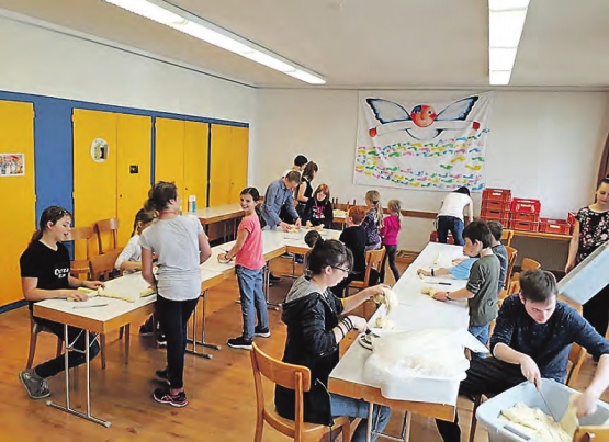 Mitglieder vom Cevi Reinach beim Zöpfeln: Im reformierten Kirchgemeindehaus entstanden 207 Zöpfe. (Bilder: zVg.)